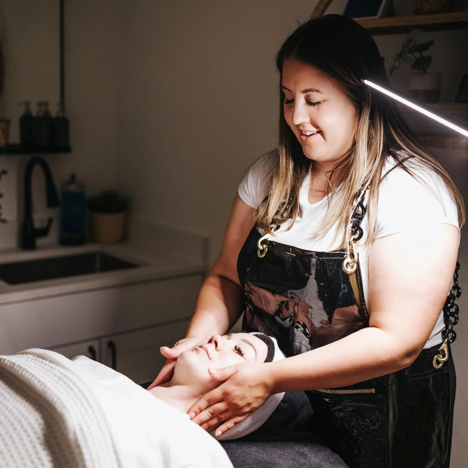 Esthetician performing a facial treatment in a skincare studio