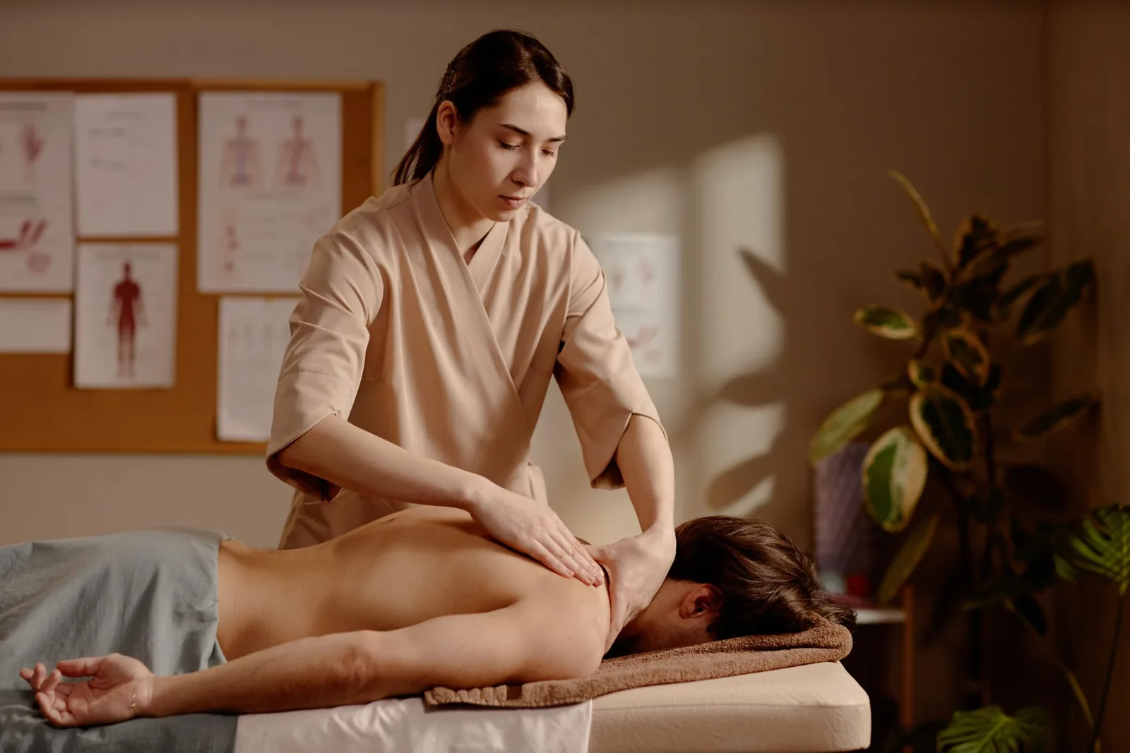 Spa practitioner providing a treatment in a private wellness room